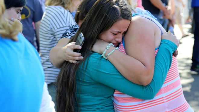 A woman is comforted as friends and family wait for students at the local fairgrounds after a shooting at Umpqua Community College in Roseburg, Ore., on 1 October 2015.