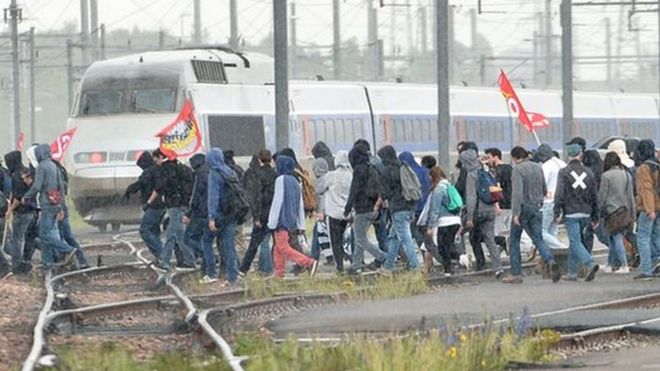 People cross railway lines during a protest against labour law reforms in Rennes, on May 26, 2016