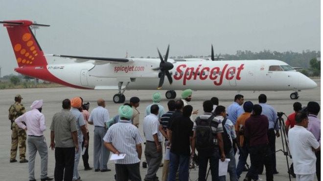 Чиновники индийского аэропорта наблюдают за прилетом самолета Spice в Раджа Санси Интернешнл
