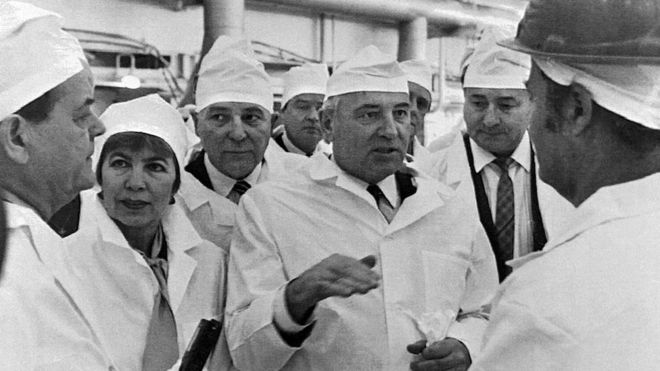 O ex-presidente soviético Mikhail Gorbachev (ao centro) e sua esposa Raisa Gorbacheva (à esq.) conversam com trabalhadores na usina nuclear em fevereiro de 1989, pouco antes do desastre
