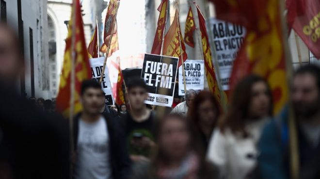 Dozens of protesters march around the Central Bank, in Buenos Aires, Argentina