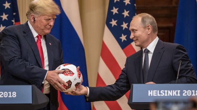President Vladimir Putin hands President Donald Trump a World Cup football during a joint press conference after their summit on July 16, 2018 in Helsinki, Finland