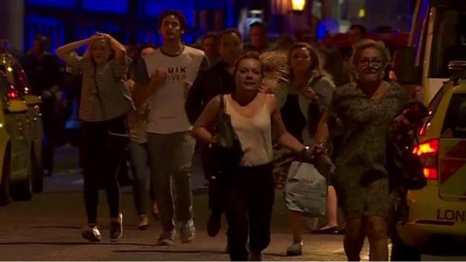 People fleeing with hands on their heads