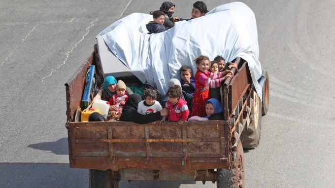 Сирийская семья, едущая на кузове грузовика, бежит из южной провинции Идлиб, Сирия (6 мая 2019 года)