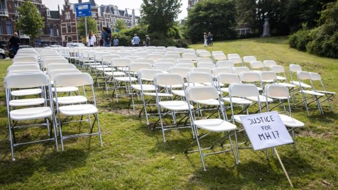Белые стулья и плакат устанавливаются родственниками жертв катастрофы рейса MH17 в качестве молчаливой акции протеста перед посольством России в Гааге в Нидерландах, 8 мая 2018 года