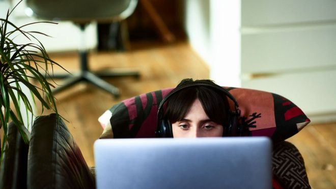 Joven viendo la computadora.