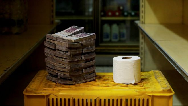 Rollo de papel higiénico junto a 2.600.000 bolívares.