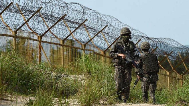 На этой раздаточной фотографии, предоставленной Министерством обороны Южной Кореи 10 августа 2015 года, южнокорейские солдаты патрулируют возле места взрыва установленных наземных мин 4 августа, ранив двух солдат, патрулирующих границу в демилитаризованной зоне, разделяющей Северную и Южную Корею, 9 августа. Август 2015 года в Паджу, Южная Корея.