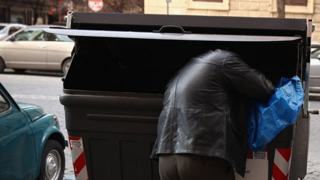 Мужчина просматривает мусорное ведро в Риме, Италия
