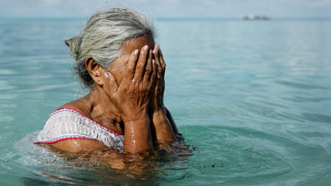 A woman stands in the lagoon on November 28, 2019 in Funafuti, Tuvalu, which has been classified as ‘extremely vulnerable’ to climate change by the United Nations Development Programme