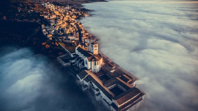 Basilica of Saint Francis of Assisi at sunset immersed in fog