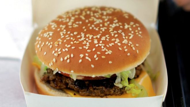 Сотрудник готовит заказы на еду в фаст-фуде Isla Burger Halal в Ницце, Франция