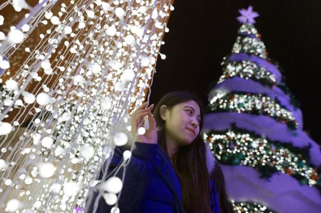 2018年12月22日，北京一名女士在聖誕樹旁自拍。