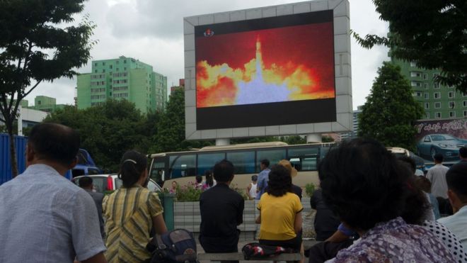 People watch coverage of an ICBM missile test on a screen in a public square in Pyongyang on July 29, 2017.
