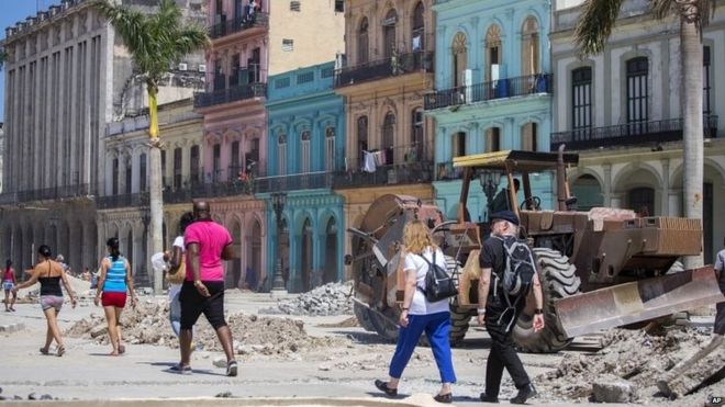 Люди гуляют на фоне ремонтных работ в центральной Гаване 10/03/2016