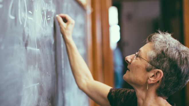 Mujer escribiendo en la pizarra