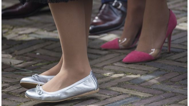 Мужчина в плоских шикарных туфлях стоит рядом с женщиной на высоких каблуках и женщиной в туфлях на плоской подошве