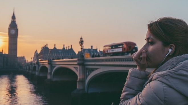 امرأة تضع سماعات التلفون في لندن - نهر التيمز