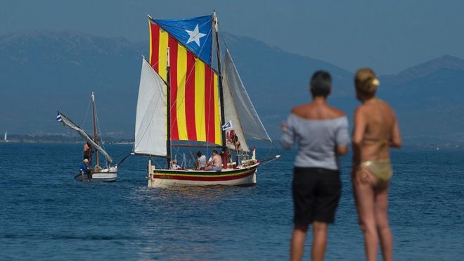Парусник с Эстеладой, каталонским флагом независимости, приплывает у пляжа Эскала, недалеко от Жироны, 10 сентября 2016 года, в канун Национального дня Каталонии, или Диады