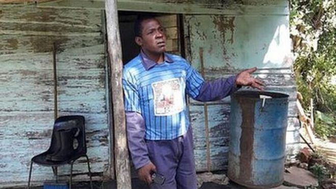 Un hombre frente a una casa miseria