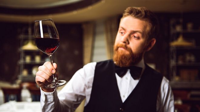 Hombre mirando una copa de vino
