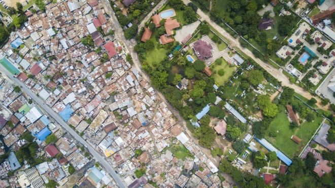 Foto aérea de grandes residencias coloniales en Oyster Bay, Sudáfrica y un asentamiento pobre vecino