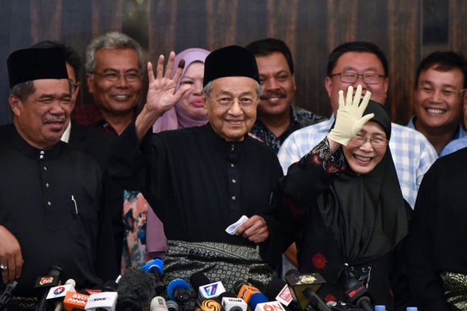 Премьер-министр Махатир Мохамад машет толпе на пресс-конференции