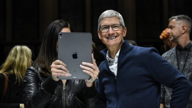 Tim Cook, CEO of Apple laughs while Lana Del Rey (with iPad) takes a photo during a launch event at the Brooklyn Academy of Music on October 30, 2018 in New York City. Apple debuted a new MacBook Pro, Mac Mini and iPad Pro.