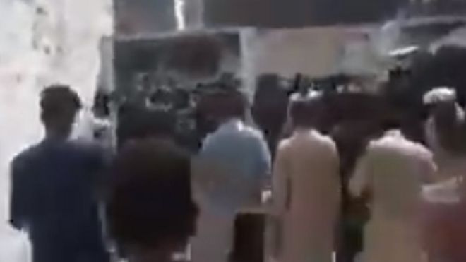 Кадр из видео, на котором мужчины идут по улице
