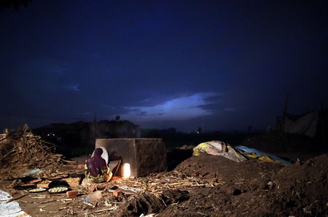 Una mujer egipcia prepara unas galletas kahk en un tradicional horno exterior al amanecer en Dalgamon, una aldea de Tanta, en el norte de El Cairo.