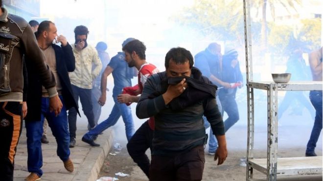 أحد المتظاهرين يغطي وجهه بعد اطلاق قوات الأمن الغاز المسيل للدموع