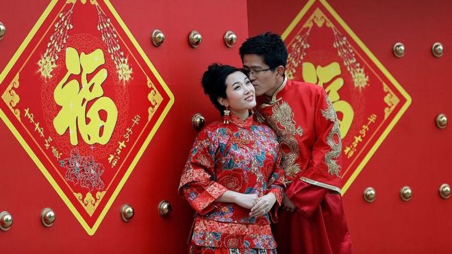Пара, одетая в традиционные китайские костюмы, имеет свадебные портреты, сделанные в День святого Валентина 14 февраля 2013 года в Пекине, Китай.