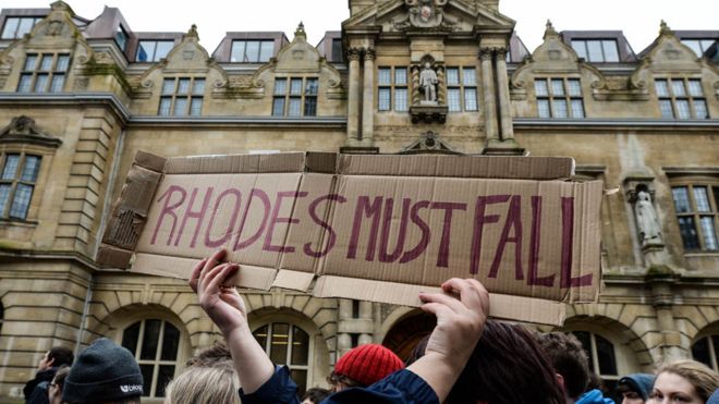Студенты маршируют мимо Ориел-колледжа Оксфордского университета в 2016 году, призывая к сносу статуи Сесила Роудса