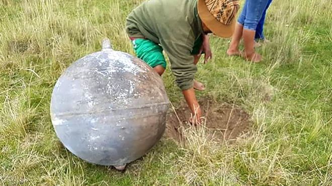 Un hombre señala el hueco que abrió en la tierra el objeto que cayó del cielo en la provincia peruana de Azángaro.