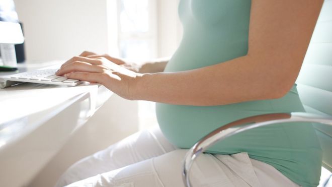 Беременная женщина с помощью компьютера