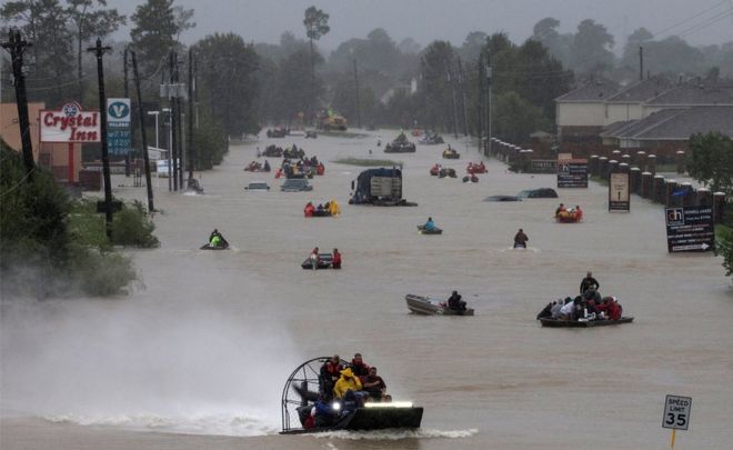 Жители используют лодки для эвакуации паводковых вод из тропического шторма Харви вдоль Тидуэлл-роуд к востоку от Хьюстона, Техас, США, 28 августа 2017 года