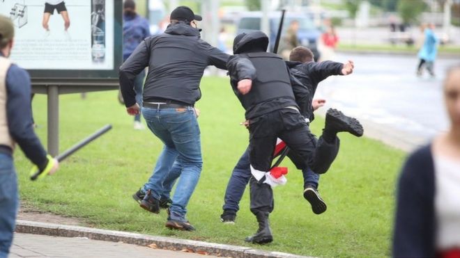 Unidentified people holding batons chase a man in an attempt to knock him down during an opposition rally to protest against police brutality and to reject the presidential election results in Minsk, Belarus September 6, 2020.