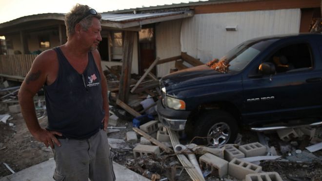 Мужчина проверяет ущерб, нанесенный его дому во Флориде после урагана Ирма в прошлом году