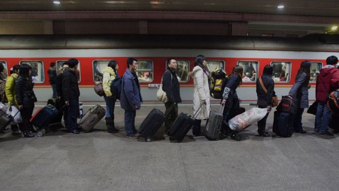 Пассажиры высаживаются в очередь на поезд на железнодорожном вокзале Шанхая 21 января 2009 года в Шанхае, Китай