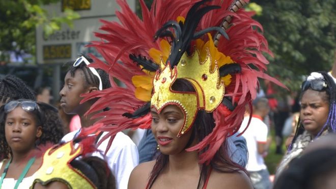 Женщина в тщательно продуманном головном уборе на параде