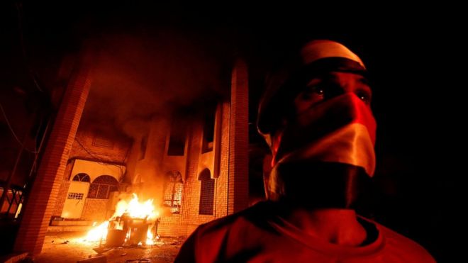 Iraqi protesters are seen near the burnt Iranian Consulate in Basra, 7 September 2018