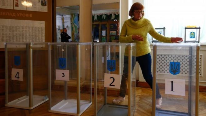 Женщина устанавливает избирательный участок в Киеве