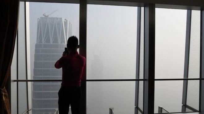 Hombre mirando la nube de contaminación en Pekín.