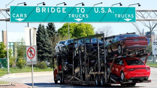 Автовоз, направляющийся в Детройт, штат Мичиган, проезжает по переулку до Амбассадор-Бридж в Виндзоре, Онтарио, Канада