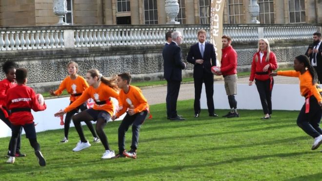 Принц Гарри смотрит, как дети играют в регби