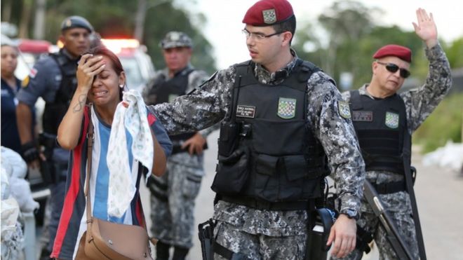 Policial consola parente de preso em frente ao presídio de Manaus