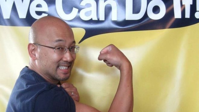 Eugene Hung flexing his muscle under a banner saying "We Can Do It!"