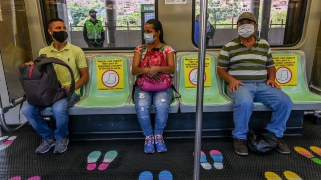 Tres personas en el transporte público en Medellín, Colombia.