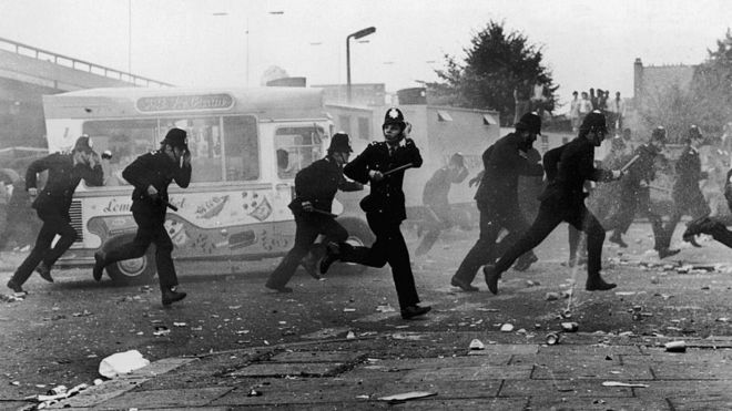 Полиция Лондона делает тактический вывод во время беспорядков, последовавших за Карнавалом в Ноттинг Хилле в 1976 году
