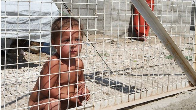 niño detrás de una reja